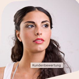 Kundenbewertung Lächelnde Frau mit blonden Haaren sitzt an einem Tisch neben einer Pflanze.